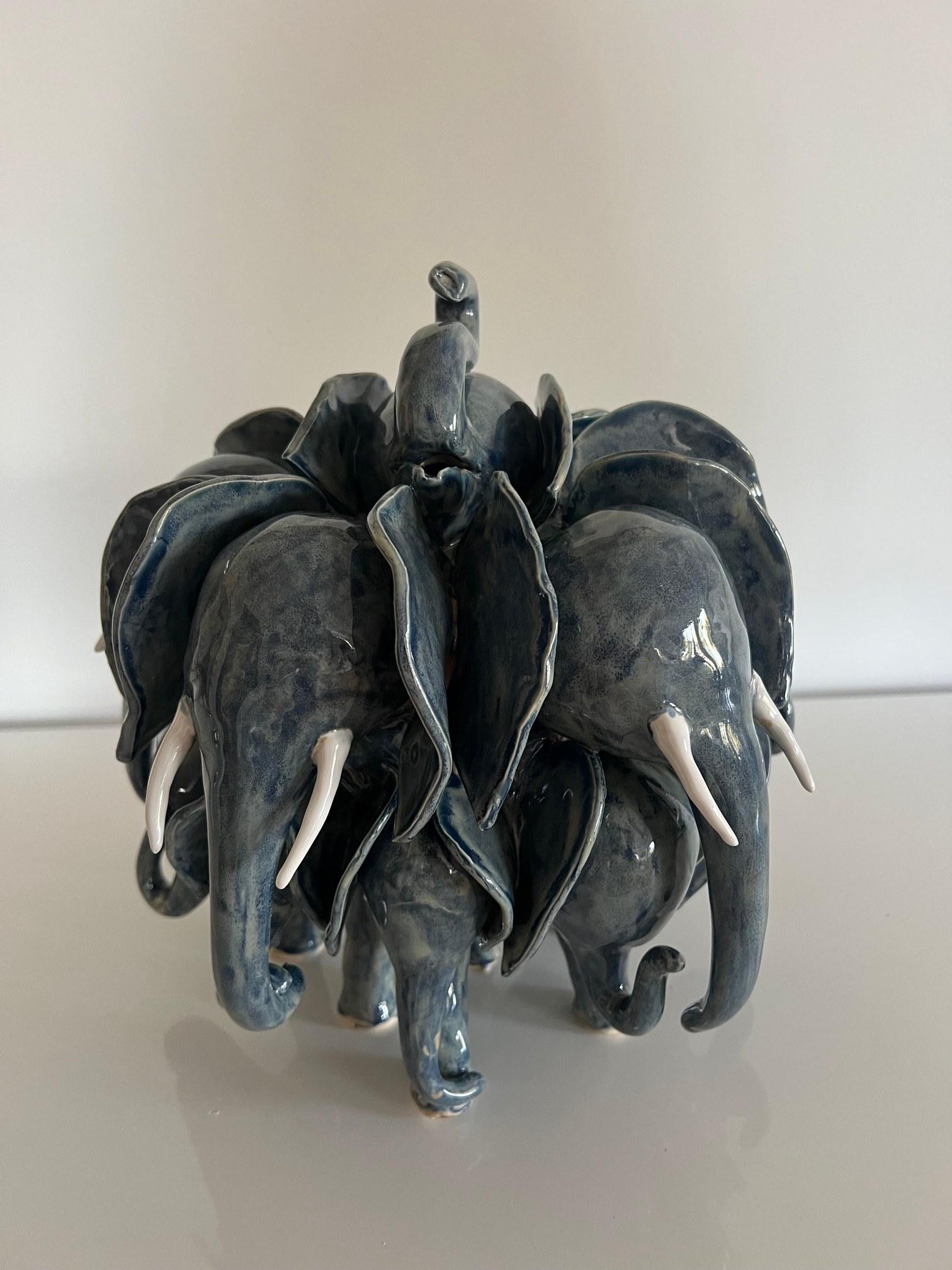 Handbuilt ceramic elephant herd glazed in deep blue, ears raised, seen from the front