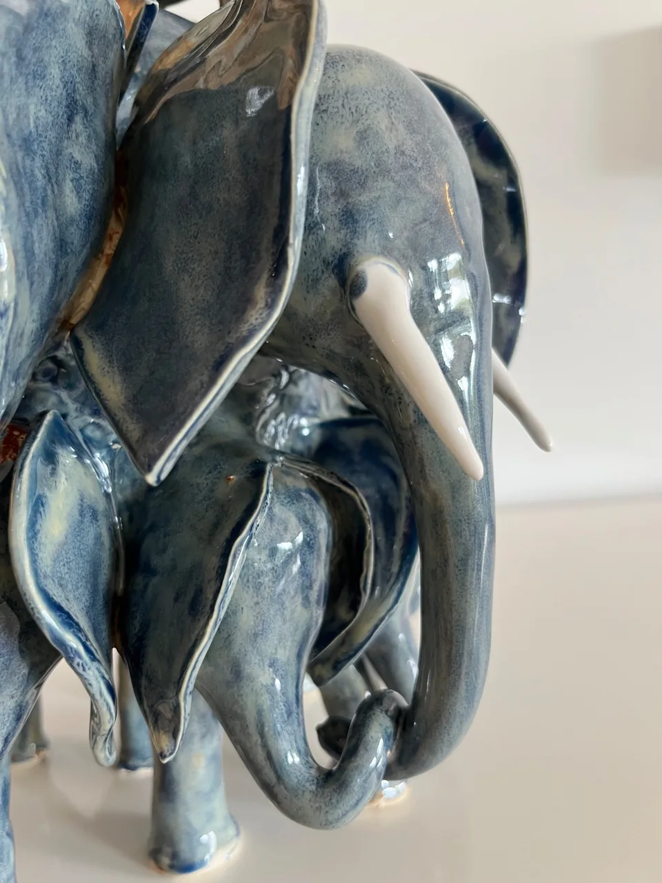 White tusks set against a blue glazed elephant herd