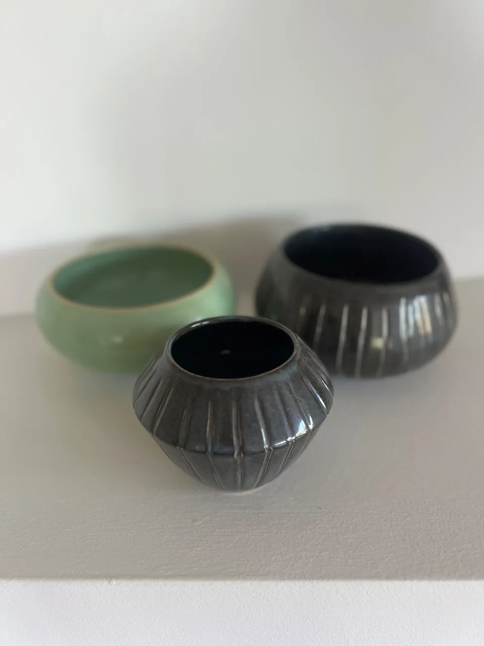 3 glazed bowls on a shelf in green and brown