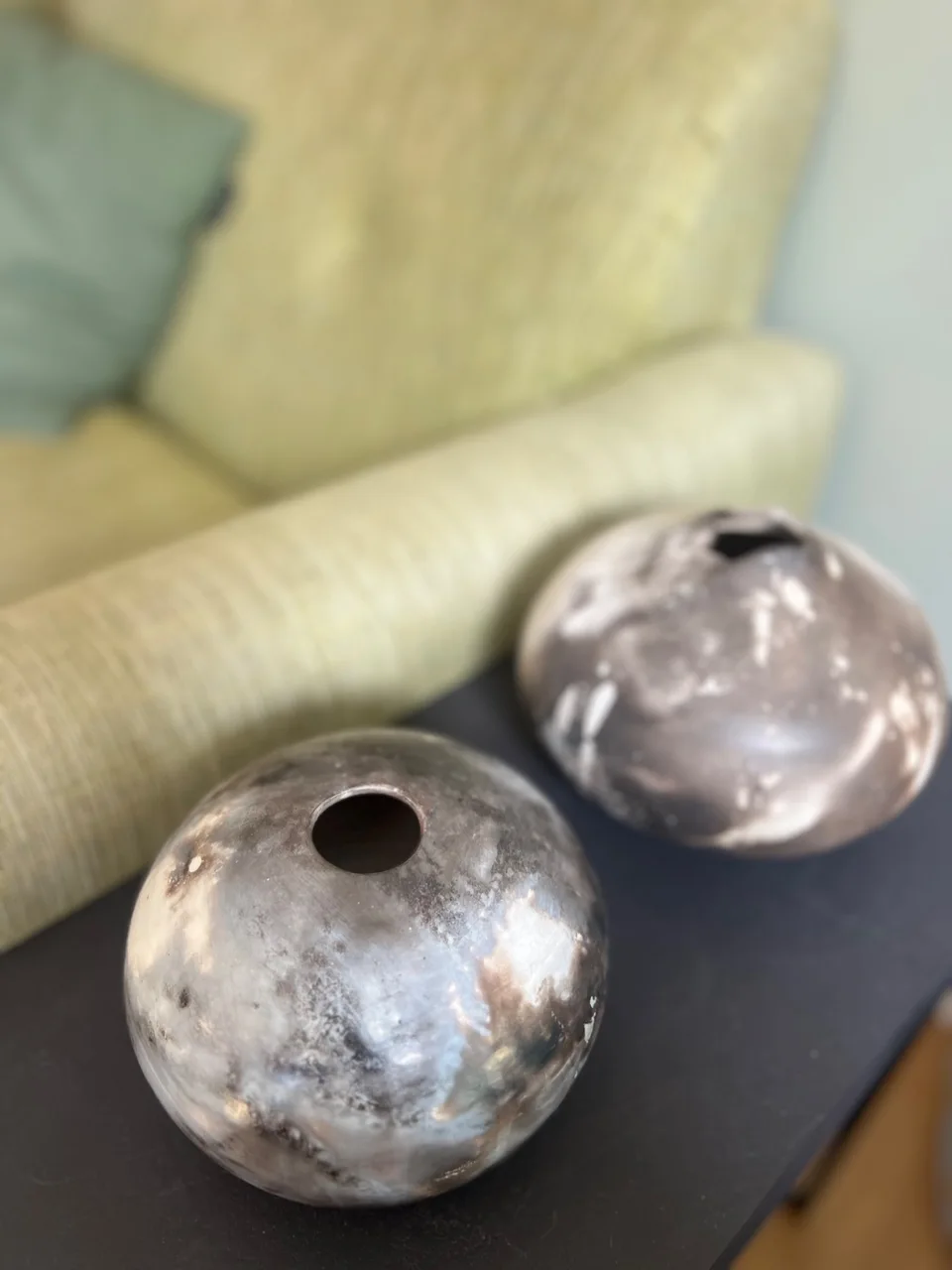 2 brown glazed ceramic sculptures on a black table